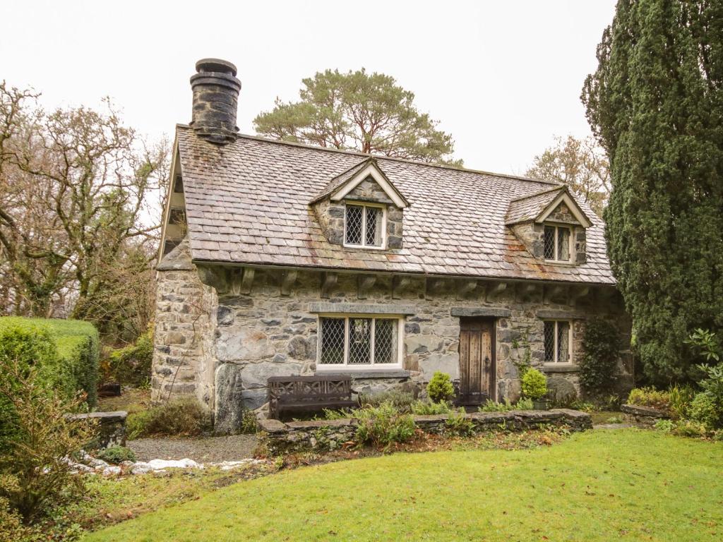 an old stone house in the middle of a yard at Nant Cottage in Llanrwst