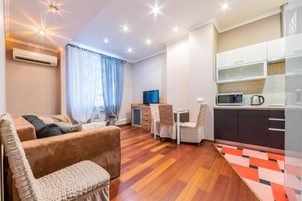 ein Wohnzimmer mit einem Sofa und einer Küche in der Unterkunft Трехкомнатная квартира на Крещатике in Kiew