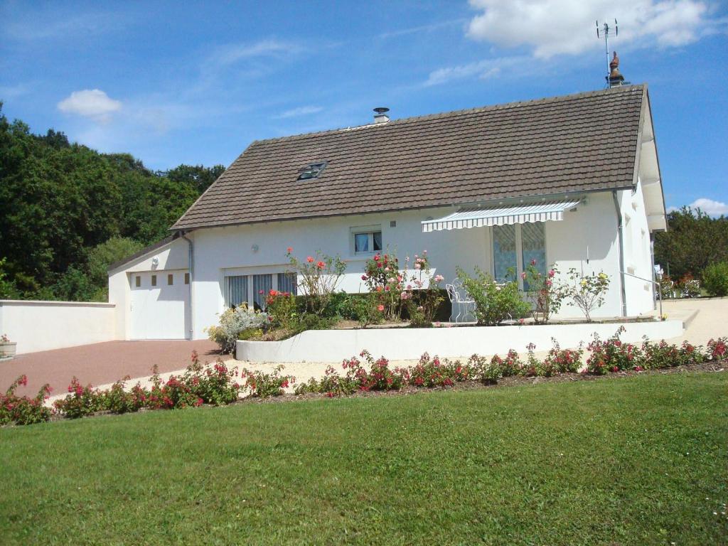 une maison blanche avec des fleurs devant elle dans l'établissement Gîte Valençay, 4 pièces, 6 personnes - FR-1-591-148, à Valençay