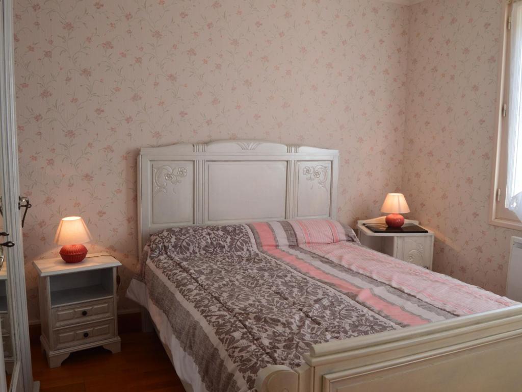 a bedroom with a white bed and two night stands at Gîte Valençay, 4 pièces, 6 personnes - FR-1-591-148 in Valençay