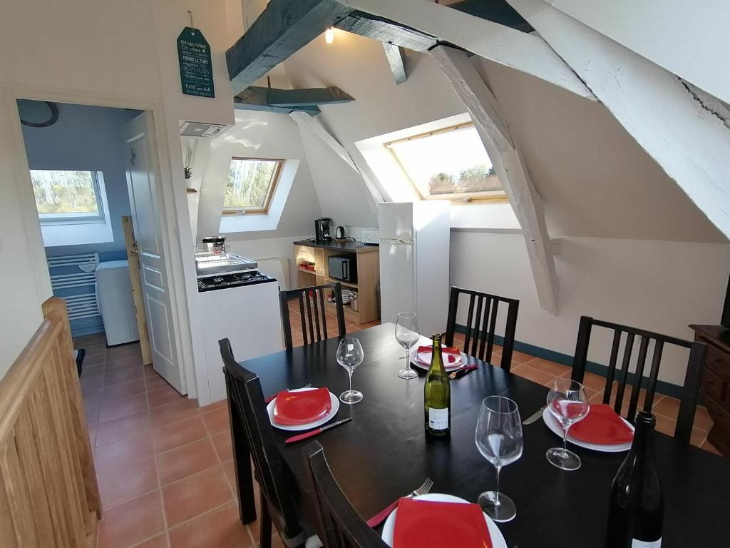 une salle à manger avec une table et des verres à vin dans l'établissement Gîte Saint-Jean-sur-Mayenne, 3 pièces, 4 personnes - FR-1-600-191, à Saint-Jean-sur-Mayenne