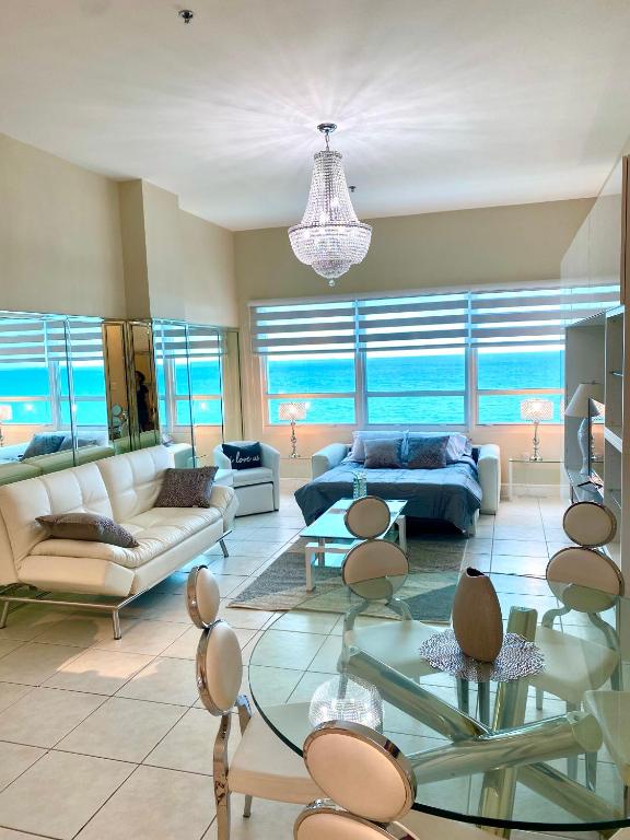 a living room with a couch and a table at Castle Beach Resort Condo - Panoramic Large Penthouse or Deluxe 1 BR Direct Ocean View and beach access- Updated-Free parking- in Miami Beach