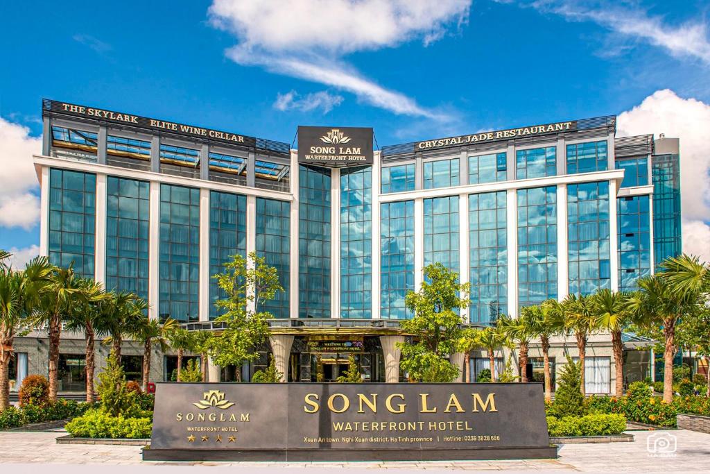 a large building with a sign in front of it at Songlam Waterfront Hotel in Hà Tĩnh