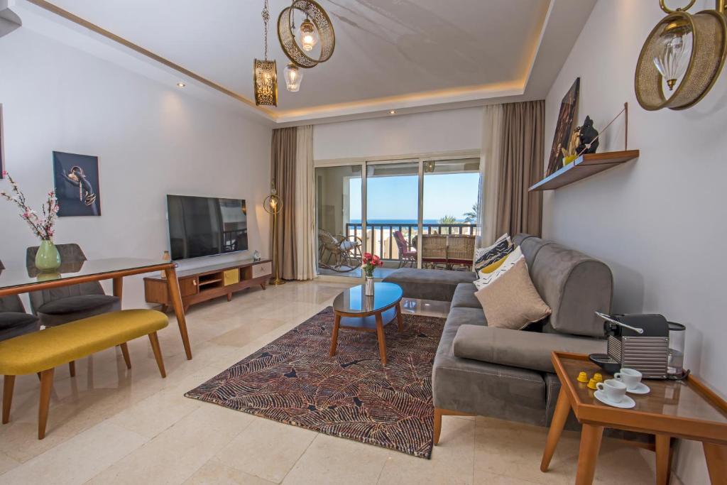 a living room with a couch and a tv at Outstanding Red Sea View-Brand New Azzurra Apartments in Hurghada