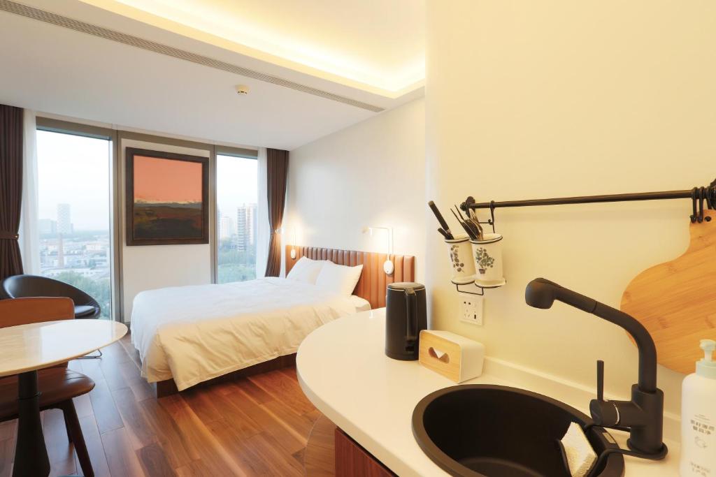 a hotel room with a bathroom with a bed and a sink at 7Shang@金尚·丽 in Beijing