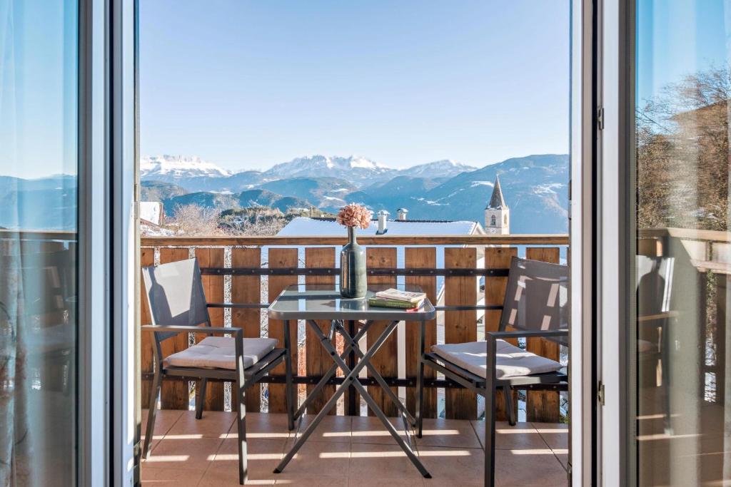 uma varanda com mesa e cadeiras e vista para as montanhas em Beckenbinder Apartement Schlern em San Genesio Atesino