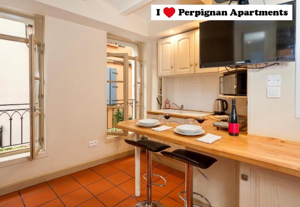 a kitchen with a counter with two stools in it at I Love Perpignan apartments in Perpignan