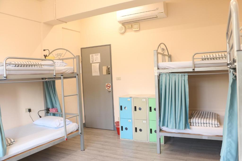 a room with three bunk beds in a hostel at On My Way - Taipei Hostel in Taipei