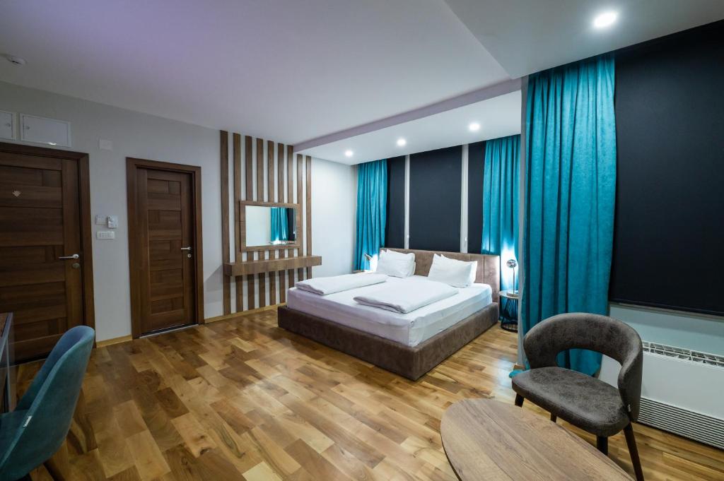 a bedroom with a bed and a table and chairs at Hotel City IN in Kočani