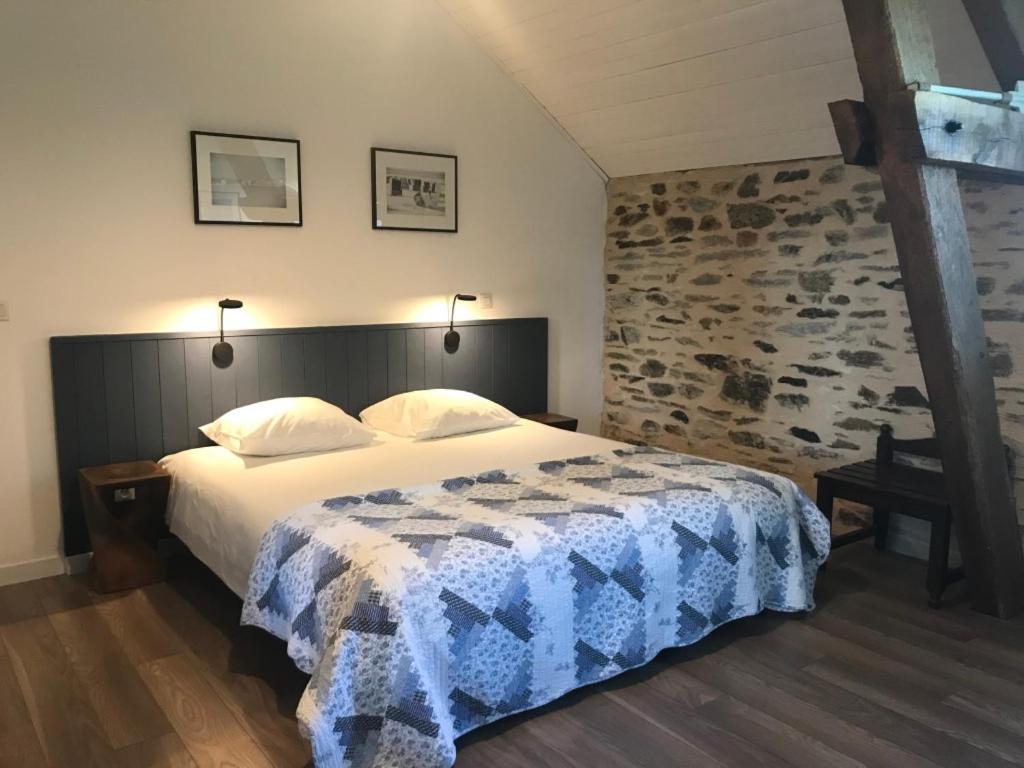 a bedroom with a bed and a stone wall at La Rame in Chalais