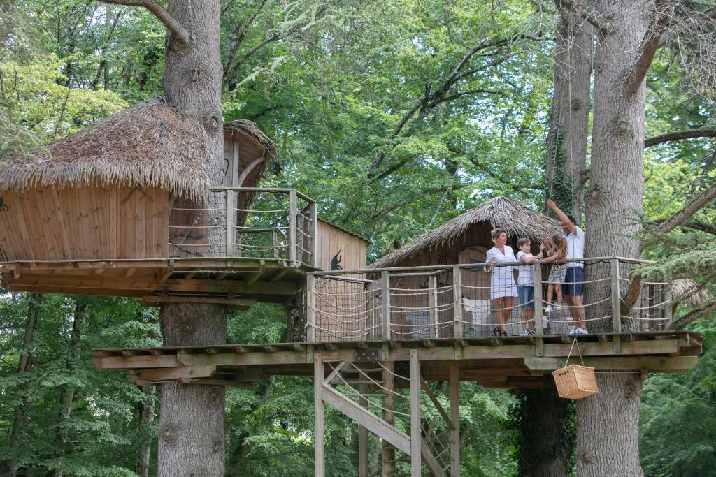 un groupe de personnes debout sur une cabane dans les arbres dans l'établissement Parc de la Belle, à Magne