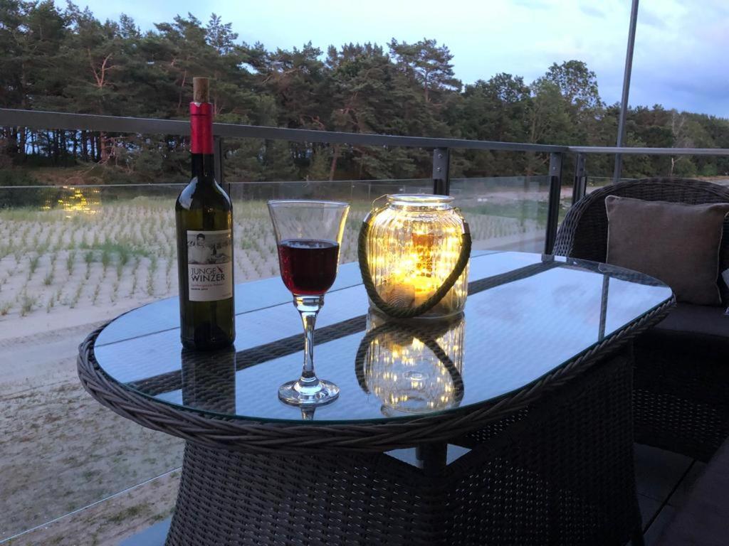 una botella de vino y una copa en una mesa en Haus Arkona - Meeresrausch, en Binz