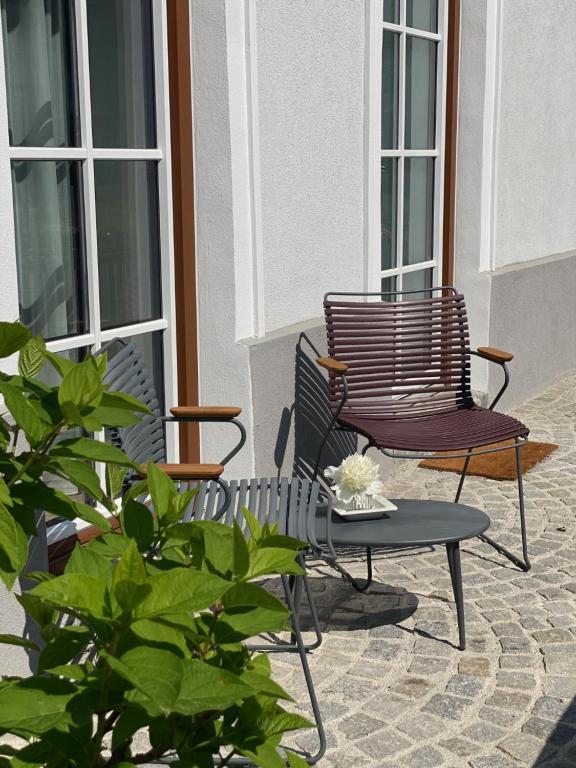ein Paar Stühle und ein Tisch auf einer Terrasse in der Unterkunft Ferienwohnung Weingut Höllerer in Engabrunn