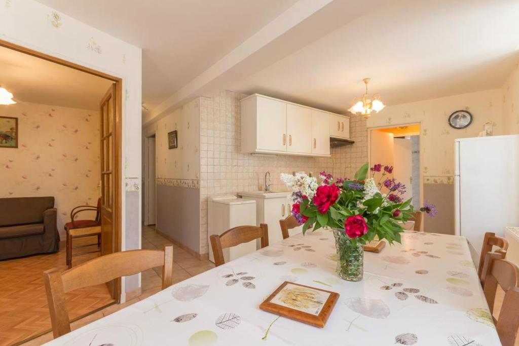 un jarrón de flores sobre una mesa en una cocina en Maison Picard, en Saint-Romain