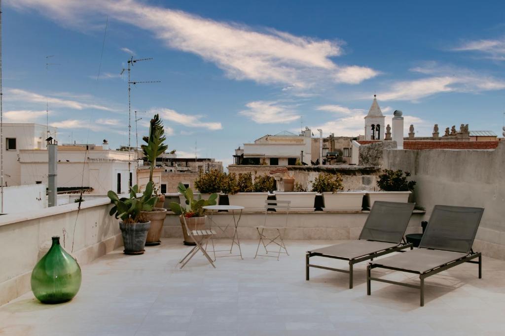 patio z 2 krzesłami i wazą na dachu w obiekcie CASA FISCARDI w mieście Bari