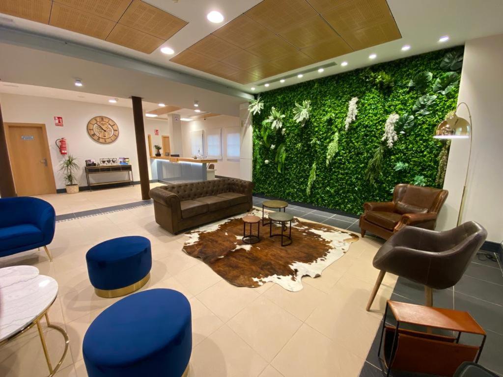 a living room with a large green wall at Hotel Camino Real in Dueñas