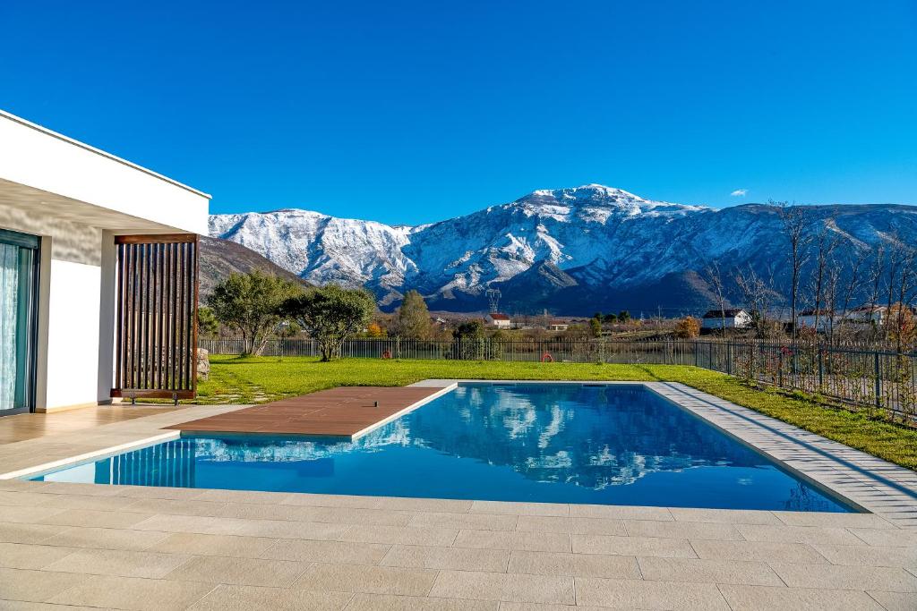 a swimming pool with mountains in the background at Villa Nera - Etwa in Mostar