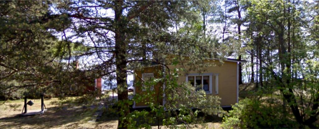 a small house in the middle of a forest at Old Finnish lakeside cottage with sauna in Oulu