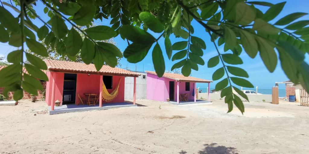 un edificio rosa e viola sulla spiaggia di Mar Aberto Hospedagem Curimãs a Barroquinha