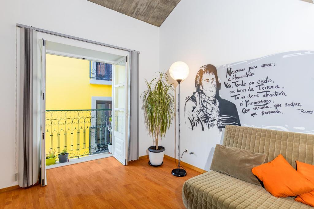 a living room with a couch and a painting on the wall at Bocage Loft (Setúbal downtown) in Setúbal
