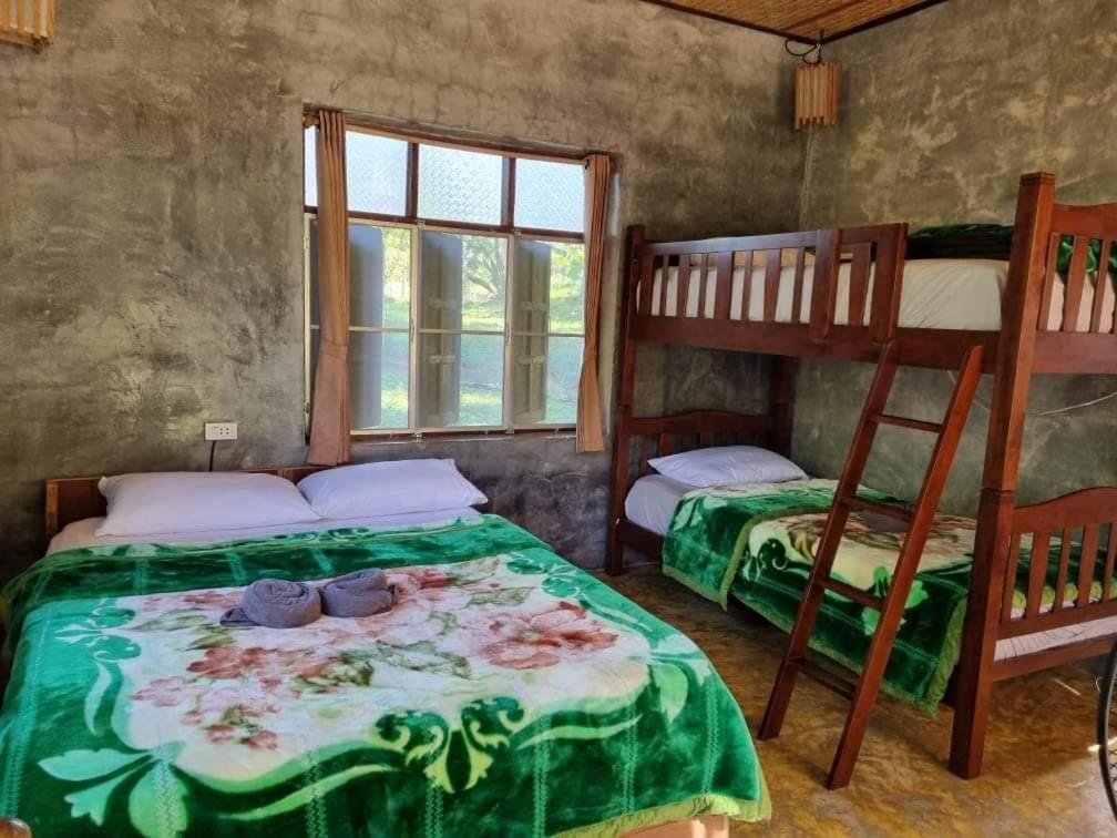 a bedroom with two bunk beds and a window at Saranghae Home Chiang Dao in Ban Tham