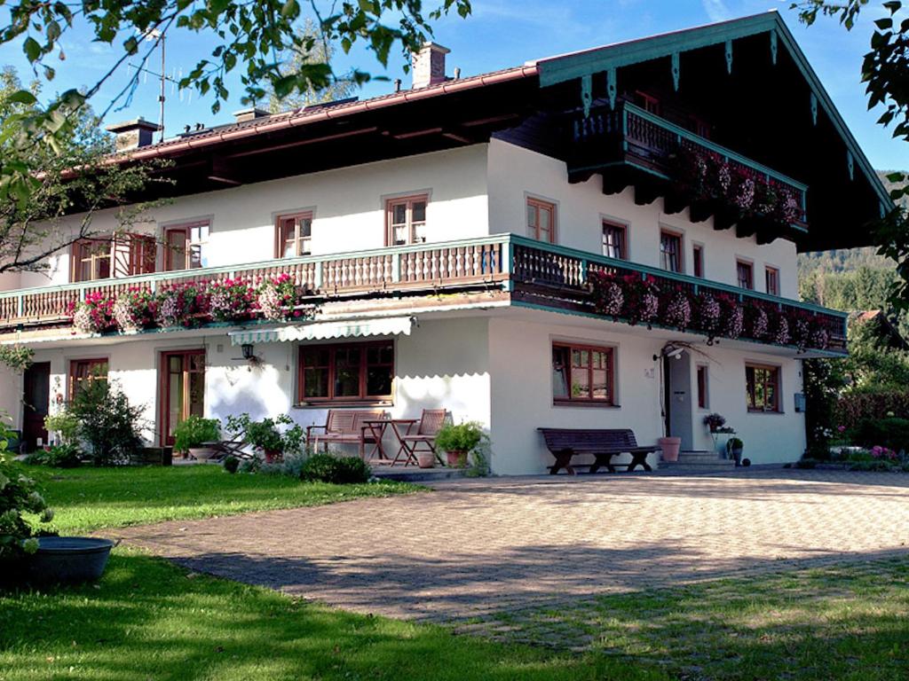 een groot wit huis met een balkon aan de zijkant bij Stachl-Hof - Chiemgau Karte in Inzell