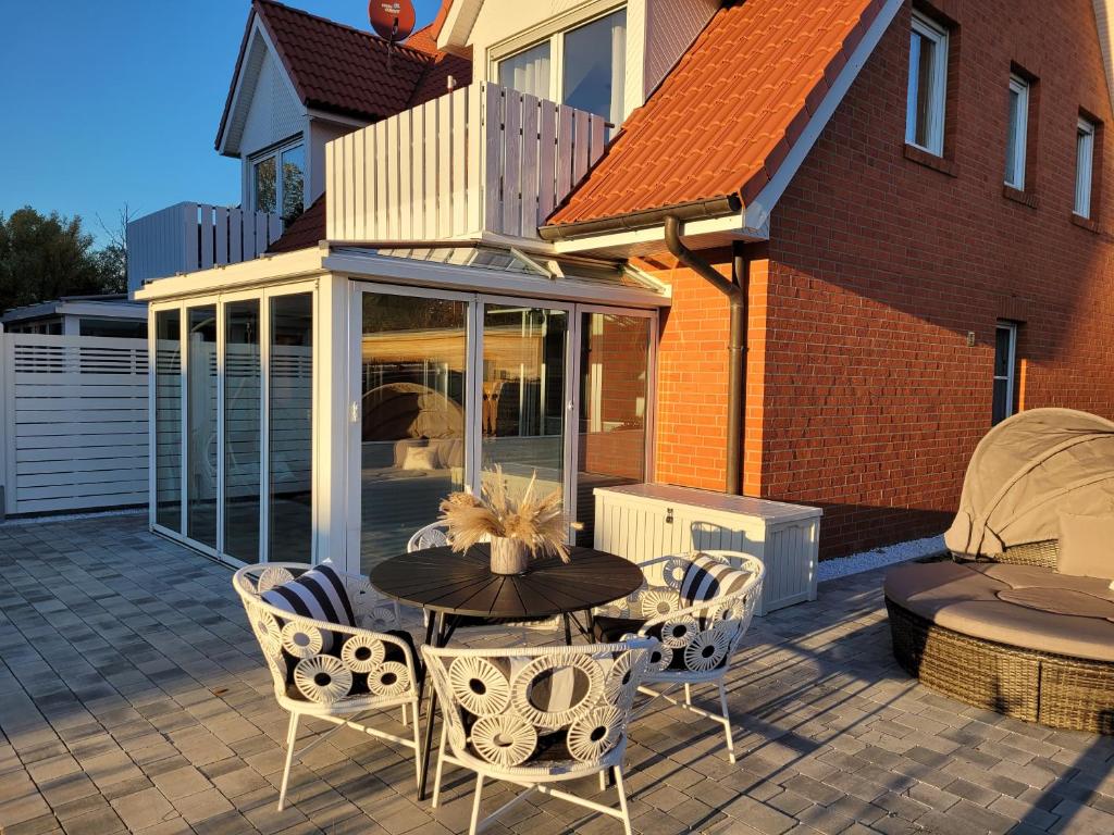 une terrasse avec une table et des chaises ainsi qu'une maison dans l'établissement Sonneninsel & Ankerplatz Wiek, à Wiek auf Rügen