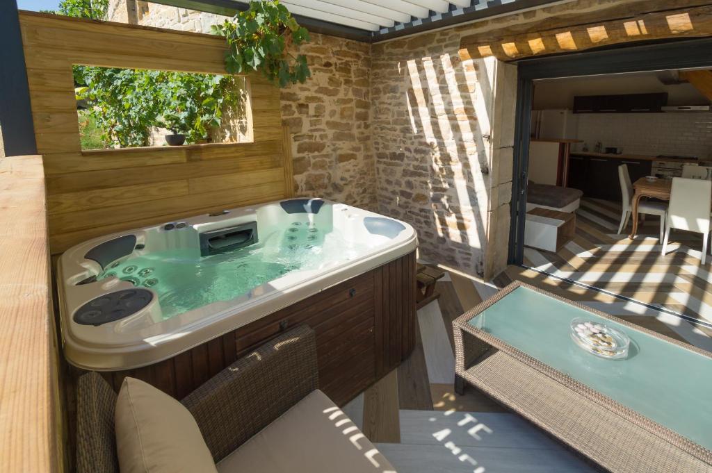 a jacuzzi tub in the backyard of a house at Gîtes d'Amelyann - gitesdesbalcons-com in Panossas