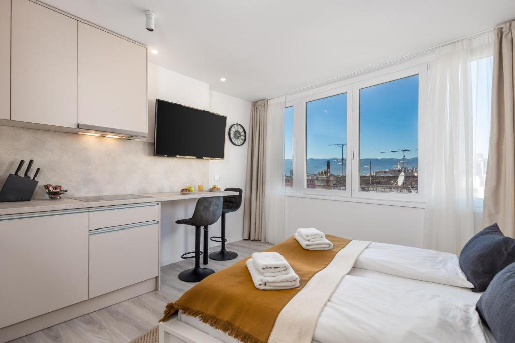 um quarto branco com uma secretária e uma cama num quarto em Apartments Penkala em Rijeka
