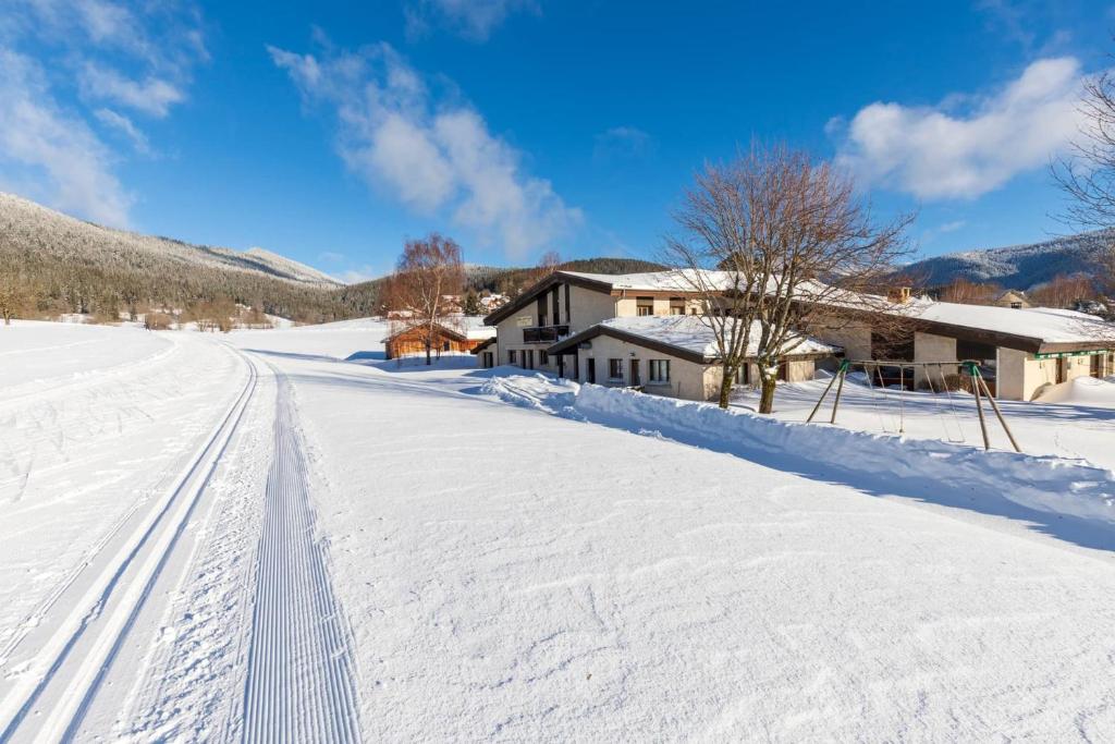 a snow covered road in front of a house at Logis Le Vernay in Autrans