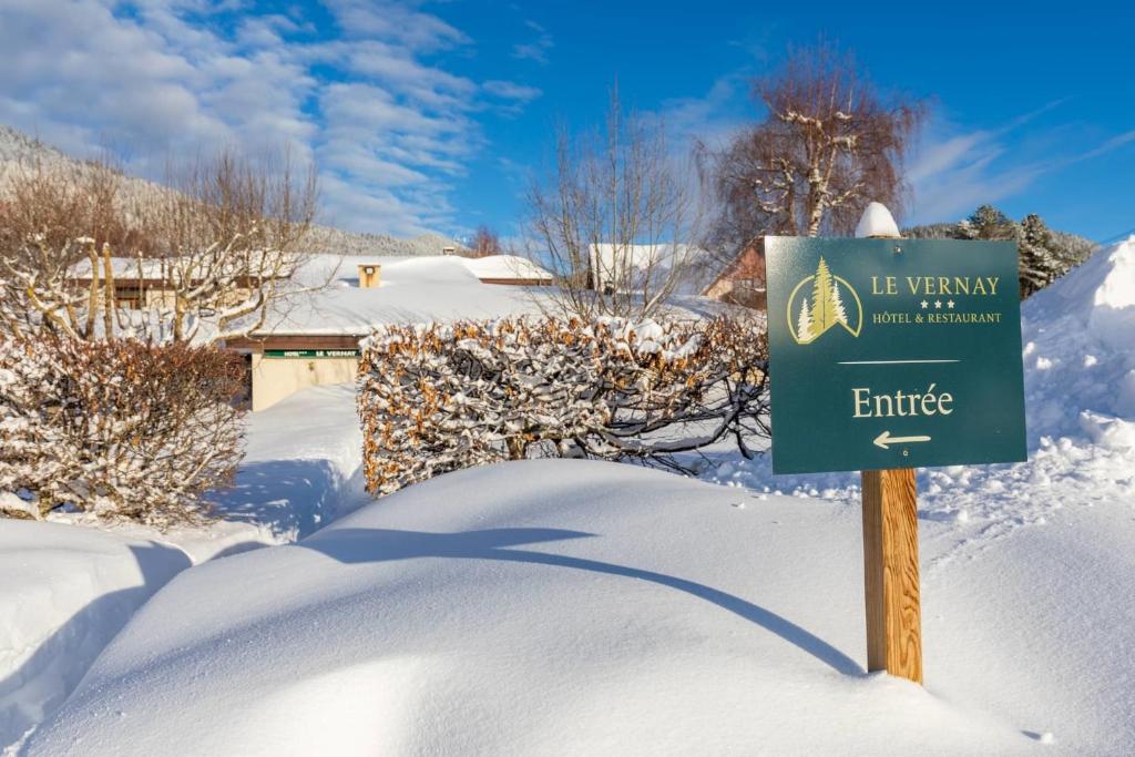 a sign in the snow in front of a house at Logis Le Vernay in Autrans