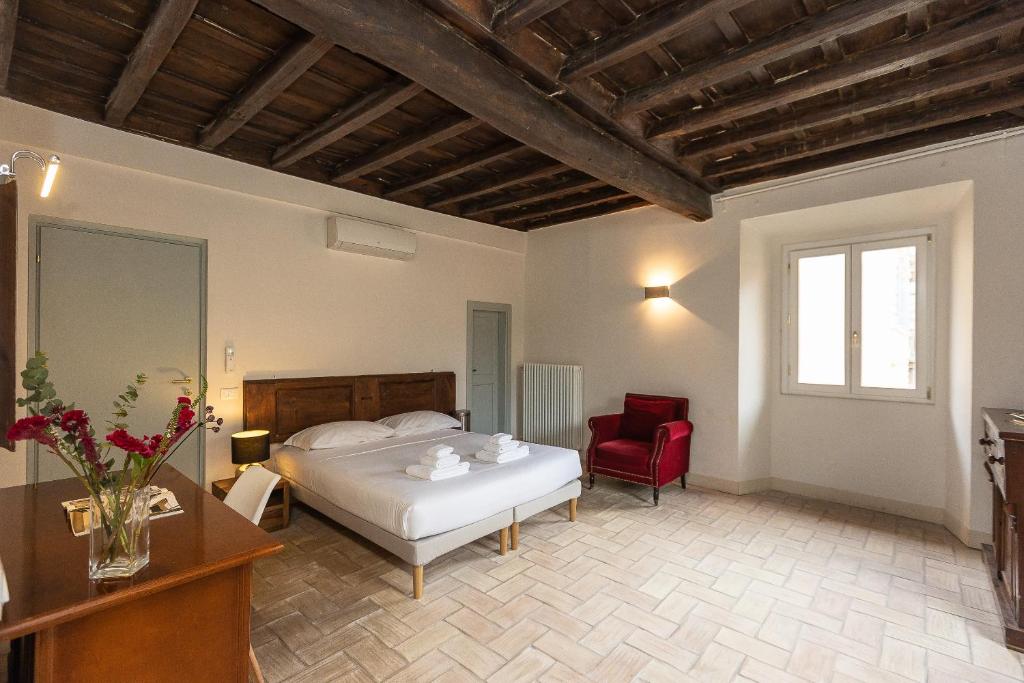 sypialnia z łóżkiem i czerwonym krzesłem w obiekcie Rome Historical Apartment - Arco dei Banchi w Rzymie