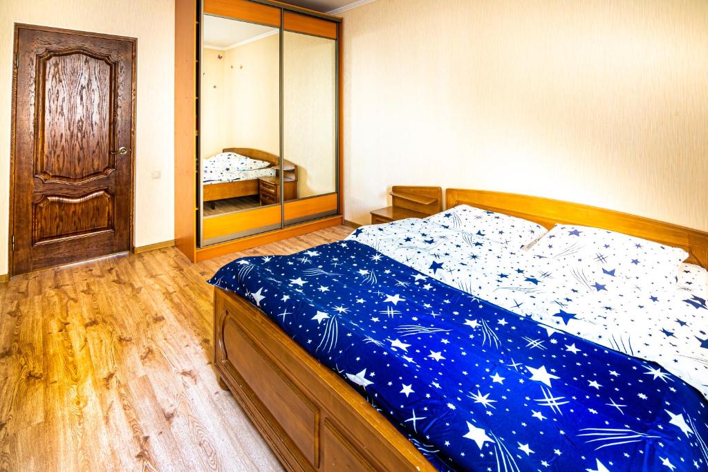 a bedroom with a bed with a blue blanket with stars at Spacious apartment at the foot of Mashuk mountain in Pyatigorsk