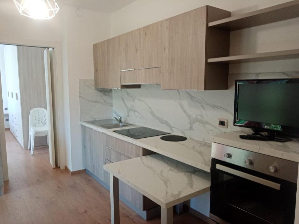 a kitchen with a desk with a monitor on it at Appartamento Prima Rosa in Primaluna