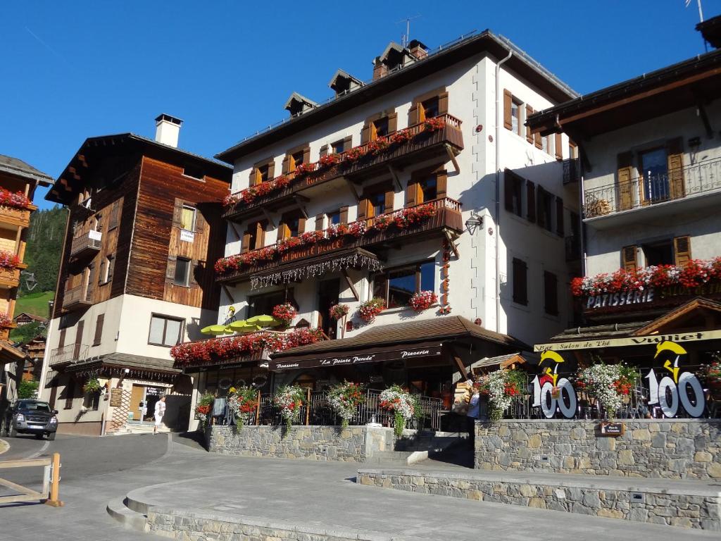 um edifício com flores nas varandas em La Pointe Percée em Le Grand-Bornand