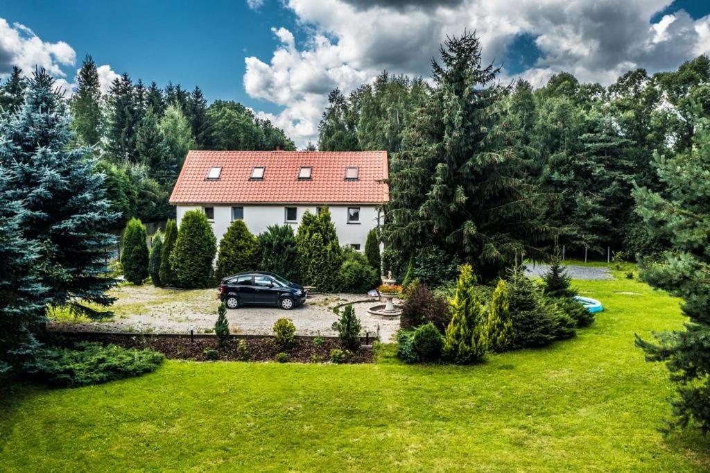 een huis met een auto in een tuin bij Karkonoska Przystań u Lisa in Chmieleń