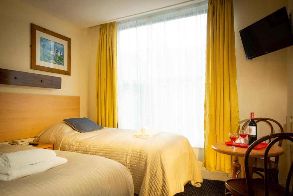 Postel nebo postele na pokoji v ubytování Ashley Hotel
