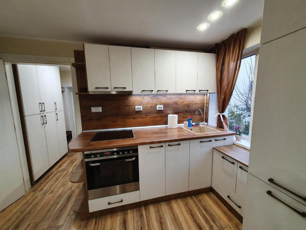 a kitchen with white cabinets and a sink and a stove at Malavi KI top center studio Ruse in Ruse