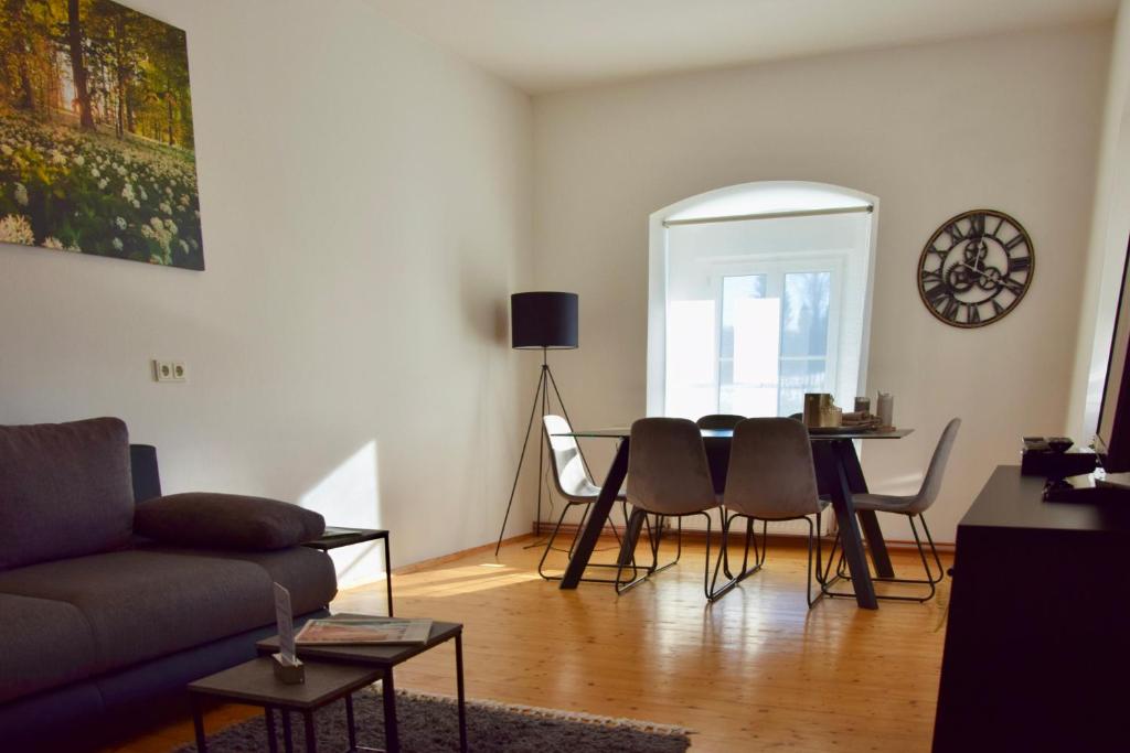 a living room with a couch and a table and chairs at Golf-Appartement in Gleisdorf