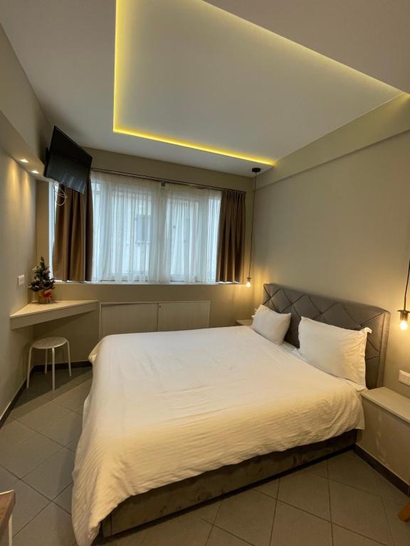 sypialnia z dużym białym łóżkiem i oknem w obiekcie Ladadika Luxury Studios w Salonikach