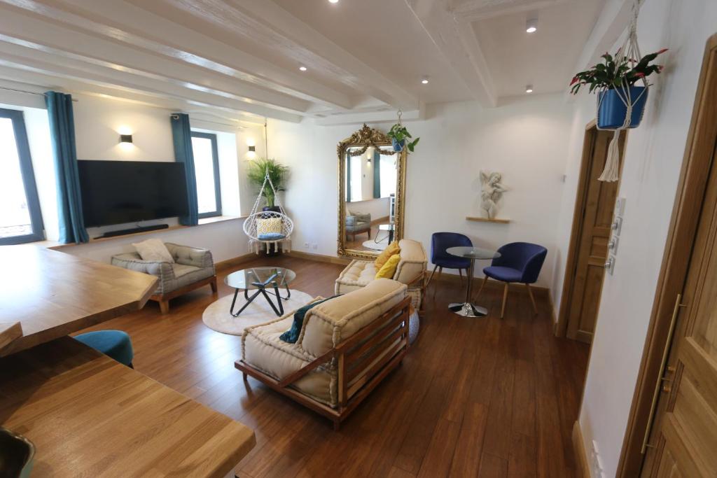 a living room filled with furniture and a flat screen tv at Le cocon aux portes de la place Stanislas in Nancy