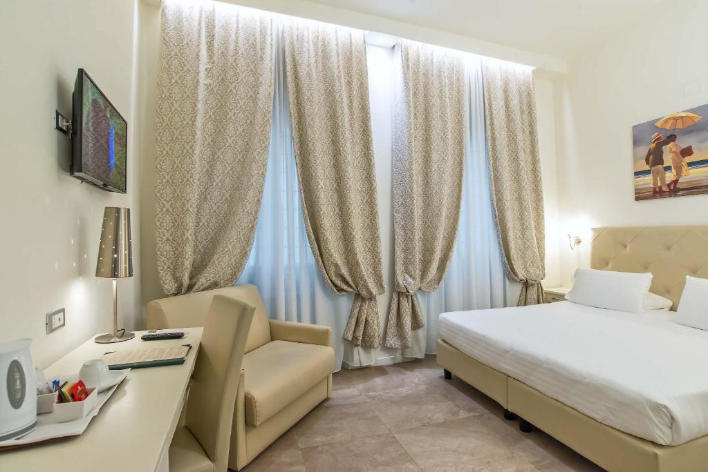 a hotel room with two beds and a television at Hotel Accademia in Florence