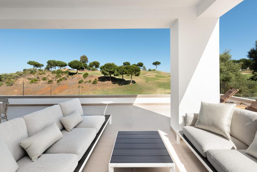 ein Wohnzimmer mit weißen Möbeln und einem großen Fenster in der Unterkunft La Cala Golf Resort 3 Bed Apt - sleek corner plot in La Cala de Mijas