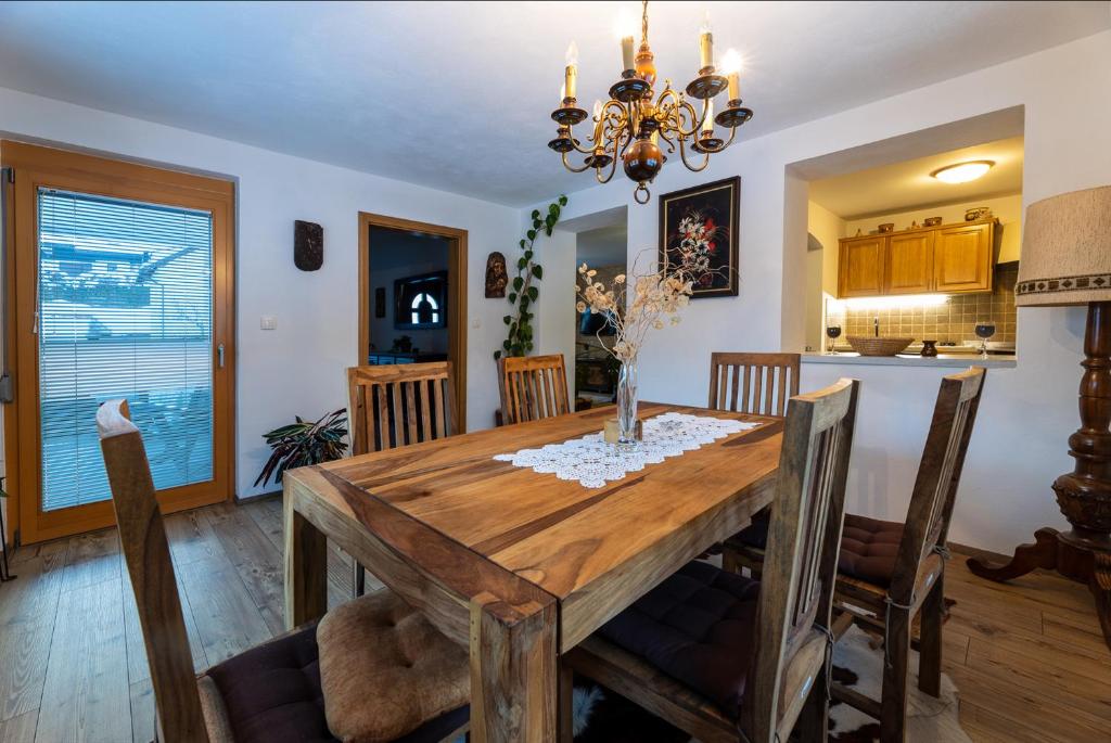 een keuken en eetkamer met een houten tafel en stoelen bij Apartma Lana in Mojstrana