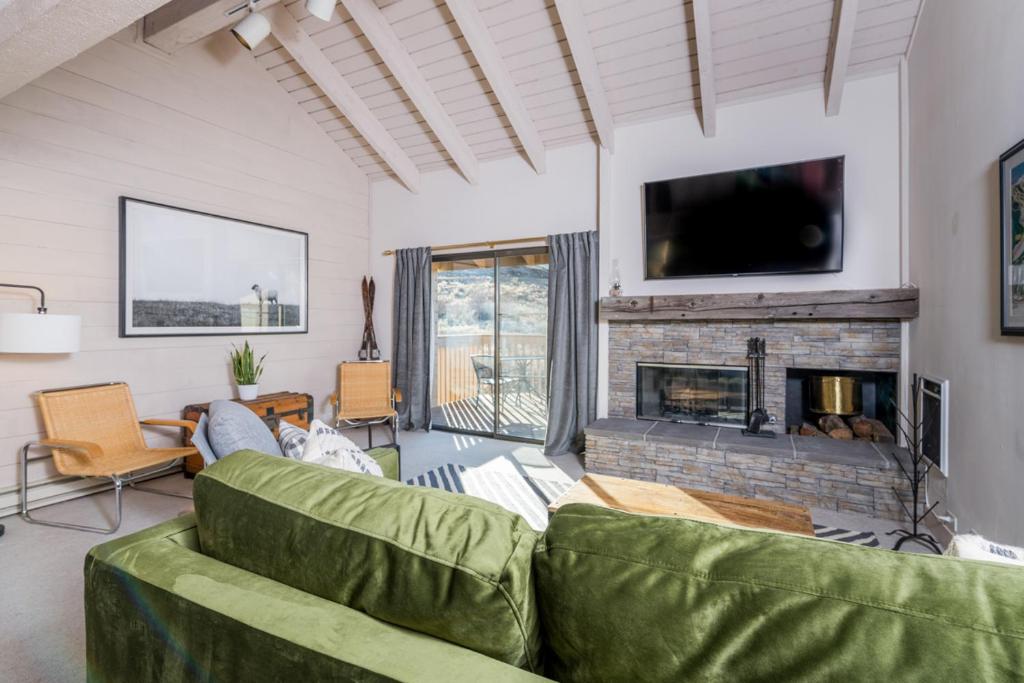 sala de estar con sofá verde y chimenea en Snowcreek 1571, en Sun Valley