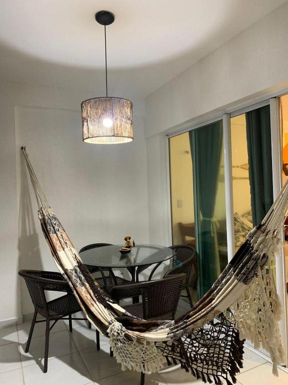 a dining room with a hammock and a table at Aloha Vibes Ap Cumbuco - Green Club in Cumbuco