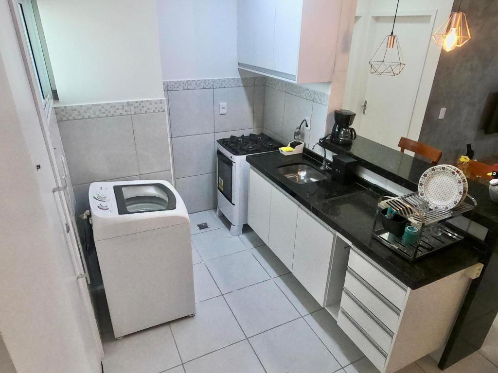a small kitchen with a sink and a stove at Aloha Vibes Ap Cumbuco - Green Club in Cumbuco
