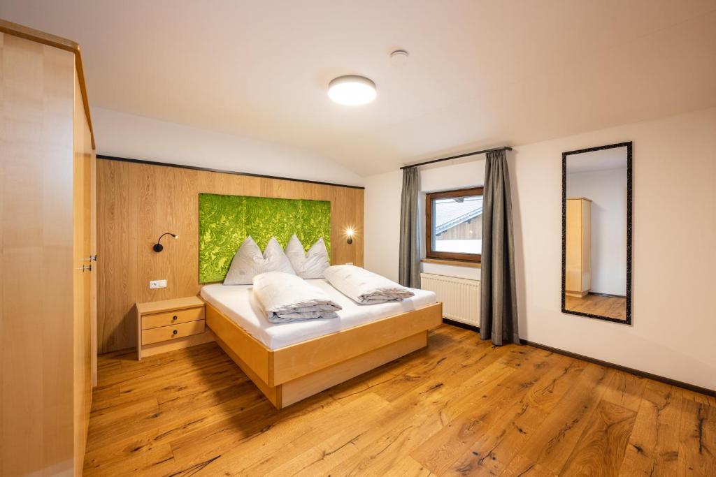 a bedroom with a bed and a large window at Wohn-Leben Altenmarkt Apartments in Altenmarkt im Pongau