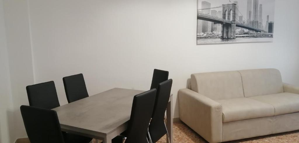 ein Esszimmer mit einem Sofa, einem Tisch und einem Stuhl in der Unterkunft Casa arcobaleno in Asti