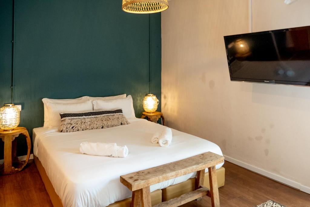 a bedroom with a bed with a tv and a bench at Beit Oren Hotel in Beit Oren